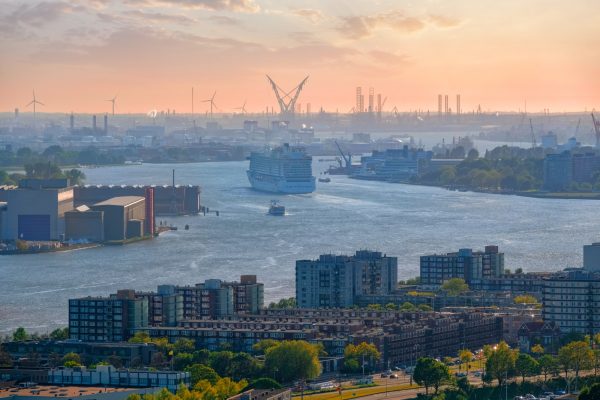 View of Rotterdam port and Nieuwe Maas river with cruise liner ship  on sunset