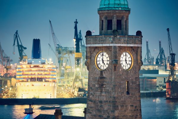Industrial skyline at the night. Historical clock tower in harbor in Hamburg, Germany.